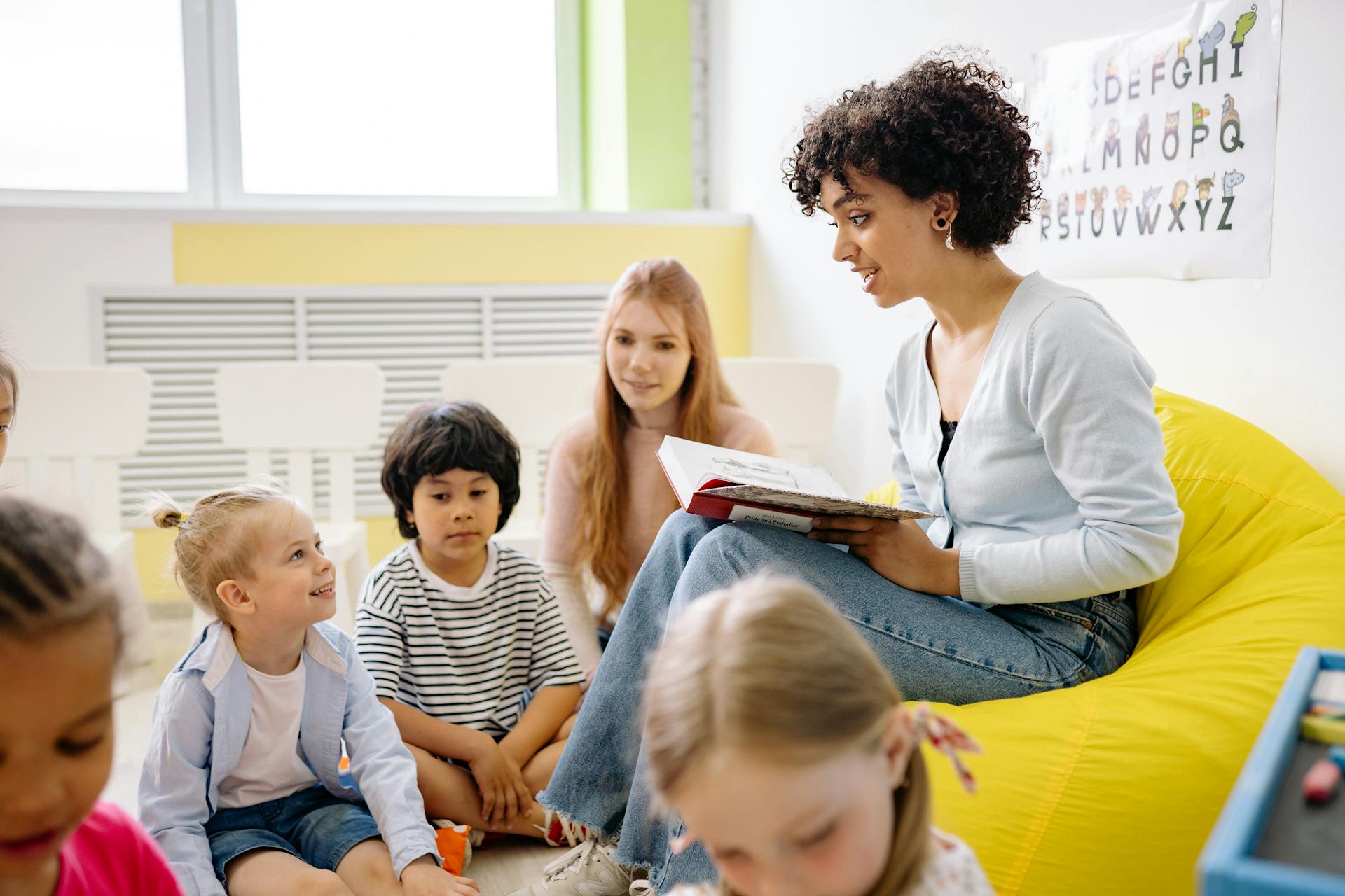 Caregiver reading to children in daycare setting